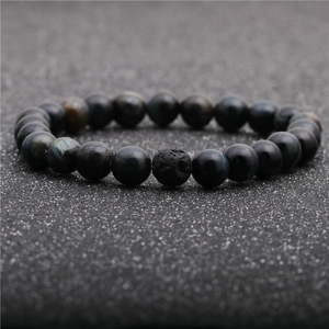Macro shot of blue tiger eye beads and textured black volcanic lava stone on a bracelet