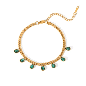 Detail of gold-tone Cuban chain with green teardrop zircon charms on white background