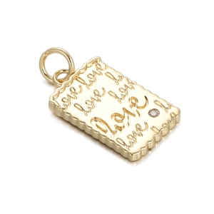 Macro detail of 18K gold plated dragonfly pendant with wave edge and love engraving
