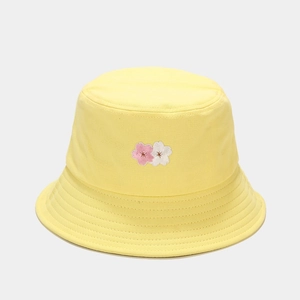 Close-up of pink cherry blossom embroidery on a yellow cotton canvas bucket hat