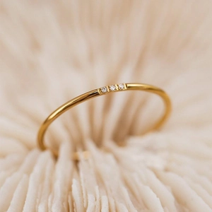 Minimalist gold titanium steel ring featuring three delicate diamonds in a row