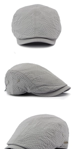 Three angles of a grey seersucker flat cap showing breathable fabric and metal eyelets