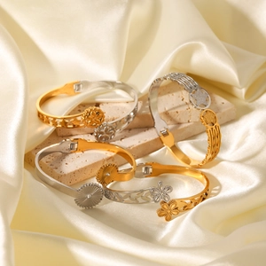 Bracelets bicolores en acier inoxydable avec motifs étoile et fleur sur marbre blanc