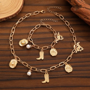 Vintage gold cowboy hat and boot pendant necklace set with pearls on wood background