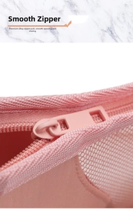 Detail of a smooth pink alloy zipper on a mesh makeup bag with clear grid texture