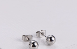 Macro view of polished silver spherical stud earrings with butterfly metal backings
