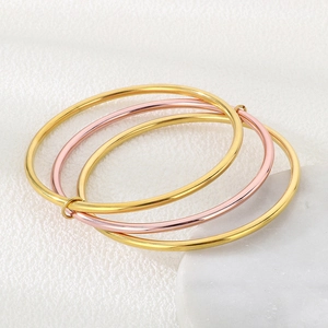 Close-up of three interlocking 3mm stainless steel bangles in gold and rose gold finish