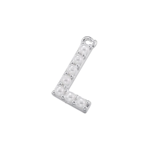 Detail shot of silver letter L pendant with small pearls and polished metal finish
