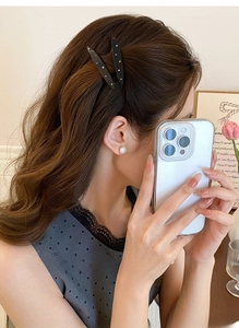 Détail de pinces à cheveux en acrylique noir avec paillettes colorées sur un mannequin