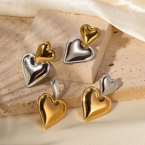 Nahaufnahme herzförmiger 18k Gold und Silber Bicolor Edelstahl-Ohrringe in Lagen-Optik