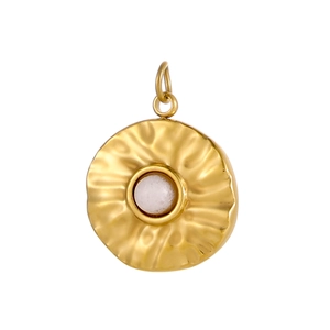 Detail of vintage gold pendant with wave-patterned texture and white gemstone inlay