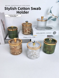 Three elegant vertical striped canisters in amber green and clear with gold trim lids