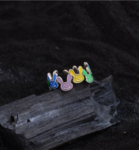 Macro shot of silver ring featuring five colorful enamel bunny heads on dark stone