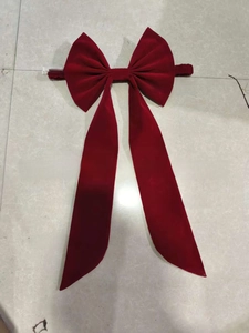 Deep red velvet giant bow decoration with long flowing ribbons for elegant event backdrops