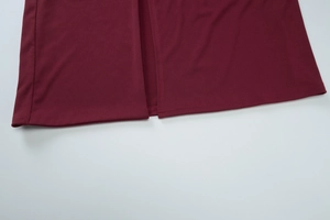 Detail view of burgundy evening dress featuring a high side slit and precise stitching