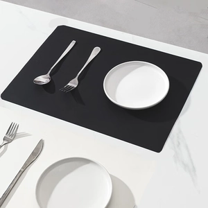 Close-up of black matte silicone heat-resistant desk mat on marble surface with cutlery