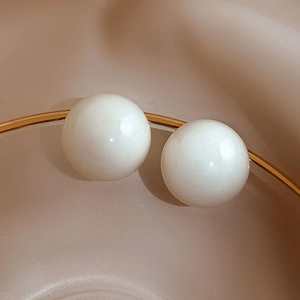 Detail shot of elegant creamy white pearls set in a polished gold curved metal frame
