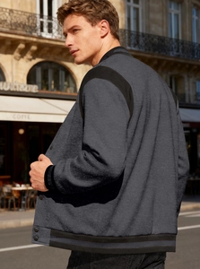 Detail of charcoal grey wool-like baseball jacket with black contrast stitching and buttons