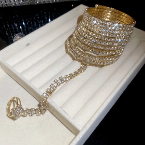 Close-up of gold plated rhinestone hand chain with multi-layer wrap bracelet and ring