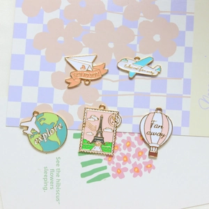 Travel-themed gold alloy enamel charms including airplane, globe, and hot air balloon motifs