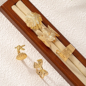 Minimalist gold leaf and butterfly ring set displayed on a premium jewelry tray