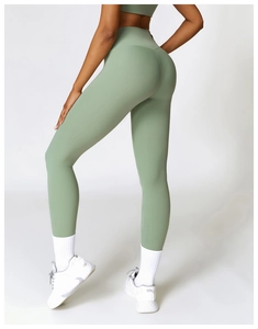 Detail of high-waist yoga leggings in sage green showing moisture-wicking fabric