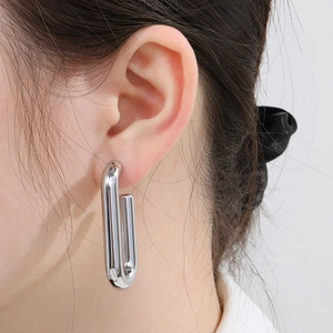 Close-up of elegant silver U-shaped oval hoop earrings in polished stainless steel