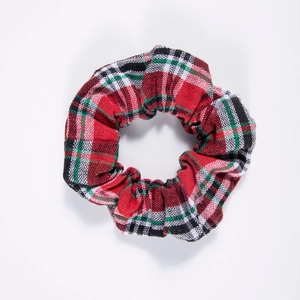 Detailed close-up of a red and green plaid fabric scrunchie with soft textile texture