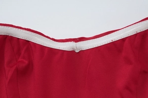Detailed close-up of the red mesh dress neckline with white elastic band and precise stitching