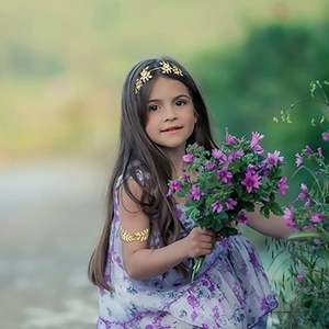 Detail of golden leaf bridal headband and arm cuff set for children in a garden