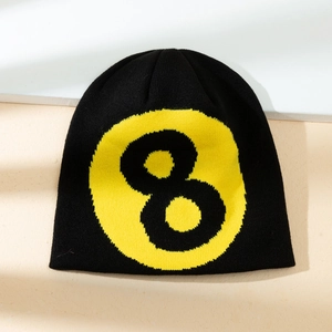 Minimalist black knit beanie with yellow number 8 pattern on textured background