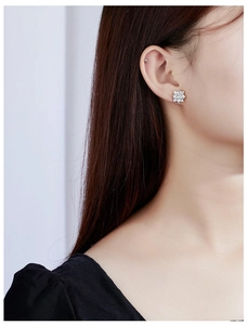 Detailed view of sparkling snowflake earrings with cubic zirconia on a model ear