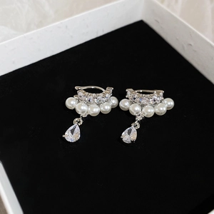 Detail of silver pearl ear cuff with zircon droplets on premium black velvet