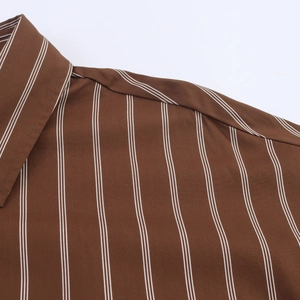 Detail of shoulder and collar tailoring on brown white striped long sleeve shirt
