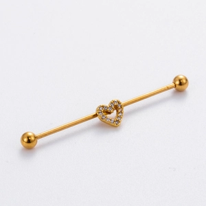 Close-up of golden industrial barbell earring with a crystal-encrusted hollow heart
