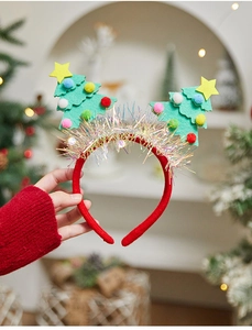 Detail of Christmas tree headband with colorful pom-poms and shiny tinsel accents