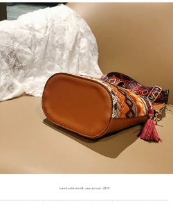 Detail of bohemian bucket bag with colorful woven patterns and a dark red tassel accent