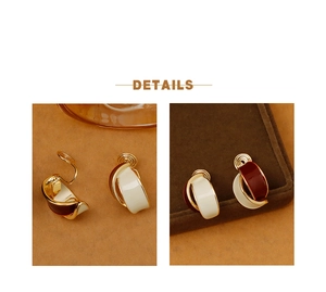 Detail of cream and dark red enamel ear clips with vintage gold metal accents