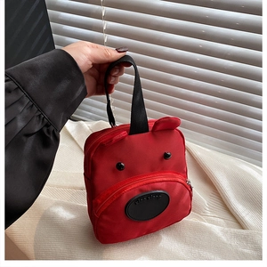Detail of red cartoon puppy handbag with 3D ears and durable black carry handles