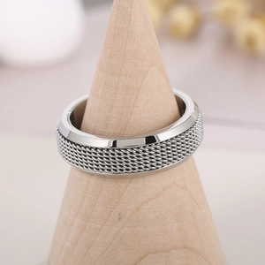 Vue macro de la bague rotative en acier argenté avec texture détaillée en maille tissée