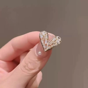Macro view of gold-plated heart brooch with shimmering pave-set cubic zirconia stones