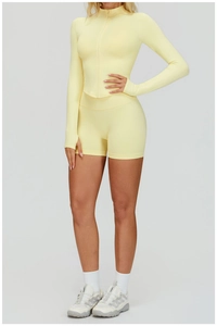 Détail d'un ensemble sans couture jaune clair avec haut zippé et short de sport taille haute