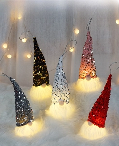 Close-up of five sequin Christmas gnome LED ornaments with plush beards and hooks