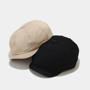 Detail view of cotton docker hats in black and beige showing stitching and twill fabric