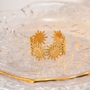 Detail of 18k gold plated sunflower ring displayed on a premium textured glass plate