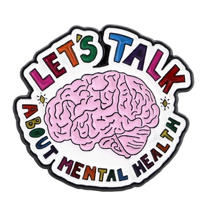 Detail of colorful mental health enamel pin with pink brain and text on white background