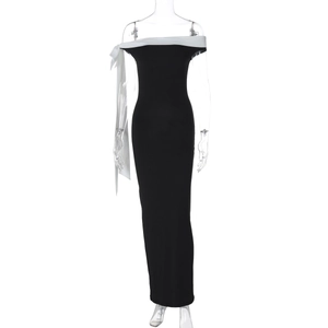 Detail of the off-shoulder neckline with a long white decorative bow on a black slim dress