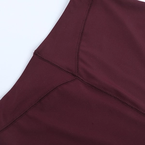 Detailed close-up of V-shaped reinforced stitching on dark burgundy yoga shorts