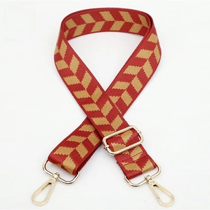 Close-up of red and gold jacquard adjustable shoulder strap with metal buckles