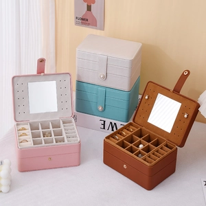 Macro view of multi-compartment jewelry boxes in pink, mint, cream, and brown leather
